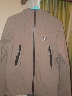 The jacket in the image is the  small 66 degreesTaupe Softshell Jacket with Hood